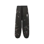 Front view of Maison Mihara Yasuhiro Black Stickers Track Pants with sticker graphic details