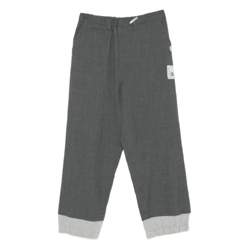 Front view of Maison Mihara Yasuhiro Cuffed Panelled Trousers with structured panel design