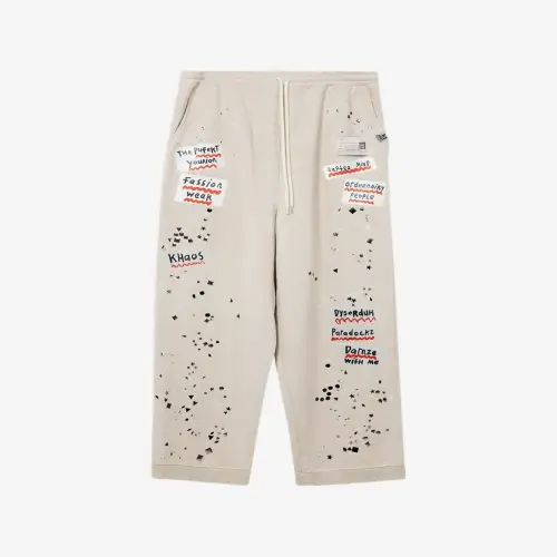 Front view of Maison Mihara Yasuhiro Embellished Sticker Sweat Trousers highlighting the decorative details.