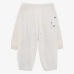 Front view of layered cotton track pants with a relaxed streetwear silhouette