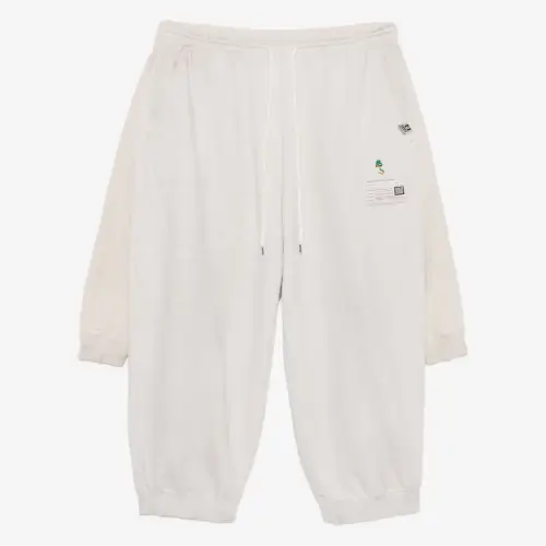 Front view of layered cotton track pants with a relaxed streetwear silhouette